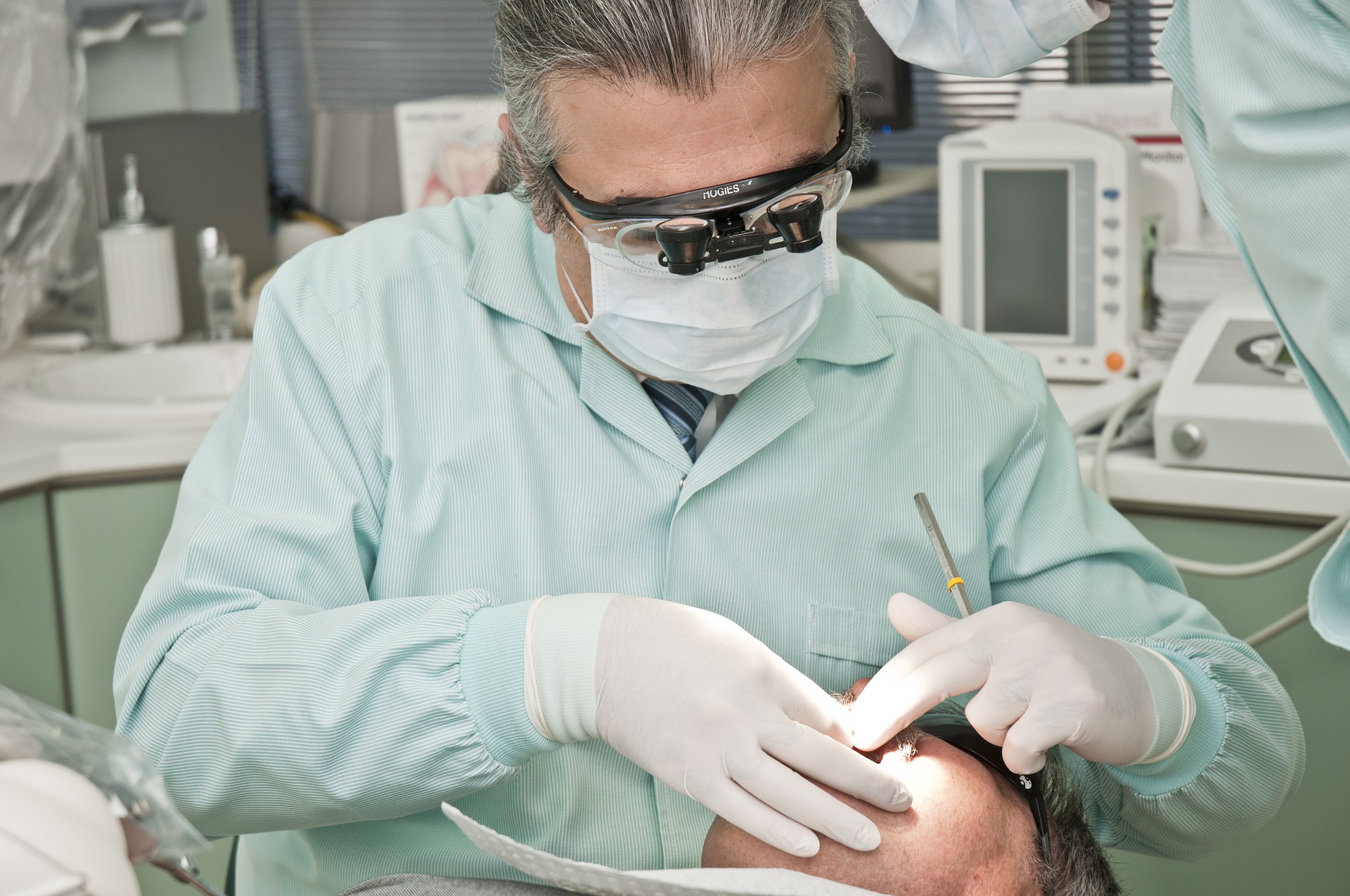 Dentiste qui est en train d'ausculter la bouche d'un patient