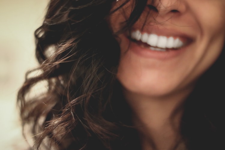 Jeune femme au beau sourire grâce à sa couronne dentaire