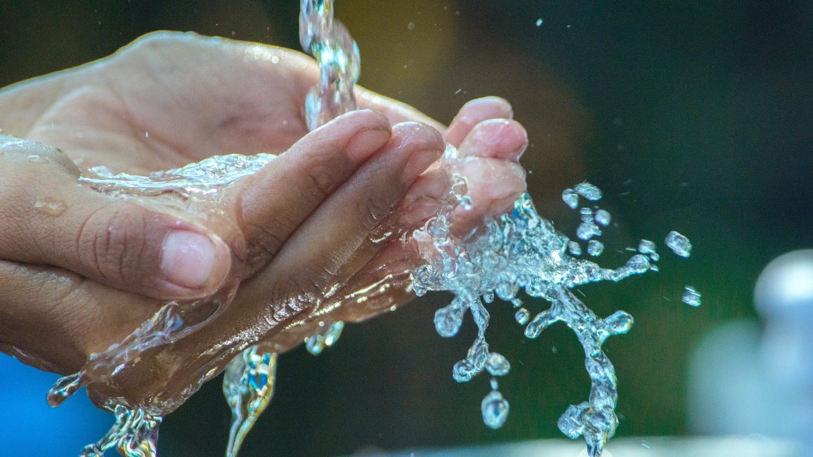 Jeune homme qui boit de l'eau du robinet potable